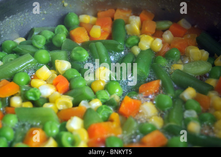 Vegetables boiling in steaming hot water in a pan. Stock Photo