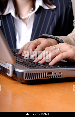 Woman Typing On The Keyboard Of A Laptop Computer Stock Photo