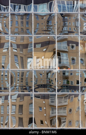 glass panels of a building in Canary Wharf, London, England distorting the reflections of another building Stock Photo