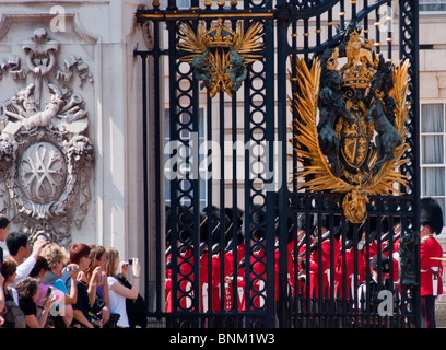 Tourists watch the 'Changing of the guard' at Buckingham palace, London. Stock Photo