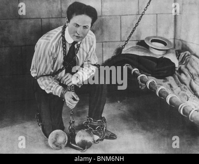 Promotional photo c1898 of magician + escapologist Harry Houdini (1874 - 1926) restrained in chains and locked in a cell. Stock Photo