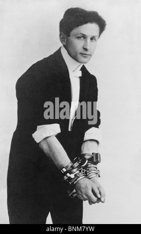 Portrait photo circa 1905 of magician and escape artist Harry Houdini (1874 - 1926) wearing multiple sets of handcuffs. Stock Photo