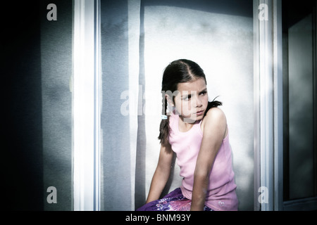 girl looking through window Stock Photo