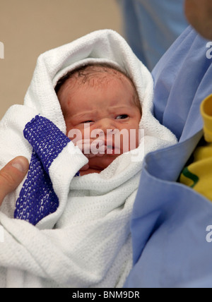 Newborn baby held by father Stock Photo