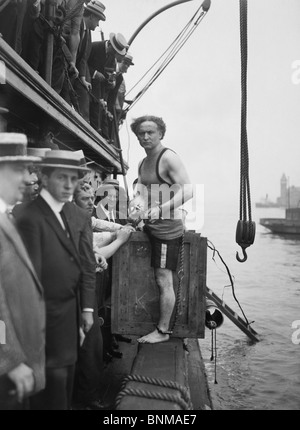 Escapologist Harry Houdini (1874 - 1926) preparing to perform his famous 'overboard box escape' for the first time in July 1912. Stock Photo