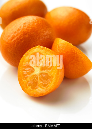 Whole and half kumquats on a white background Stock Photo