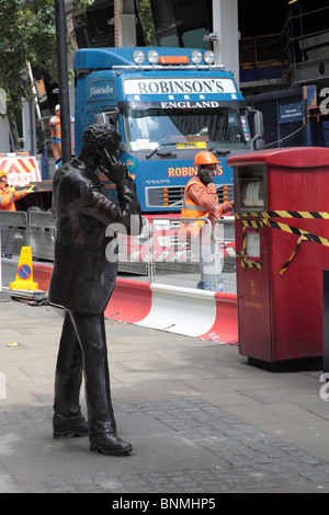Sculpture of city trader using a cellphone with a workman looking over his shoulder in Walbrook, London, EC4. Stock Photo