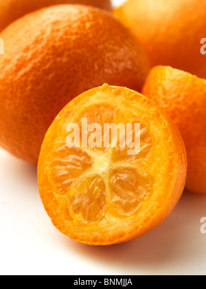 Whole and half kumquats on a white background Stock Photo