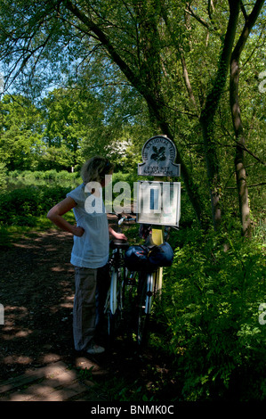 Young lady studying a map set up The National Trust River Wey Navigations, on public footpath between Guildford and Send, Surrey Stock Photo