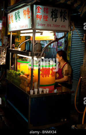 A woman sits at a juice stall in the Shilin Night Market, Taipei. Stock Photo