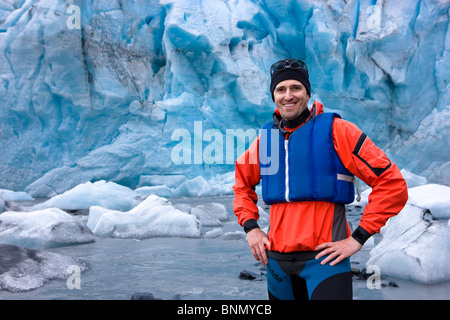 Male kayaker standing at the shoreline in front of Shoup Glacier,  Shoup Bay State Marine Park, Prince Wlliam Sound, Alaska Stock Photo