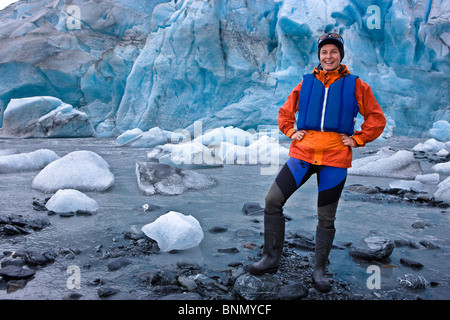 Female kayaker standing at the shoreline in front of Shoup Glacier,  Shoup Bay State Marine Park, Prince Wlliam Sound, Alaska Stock Photo