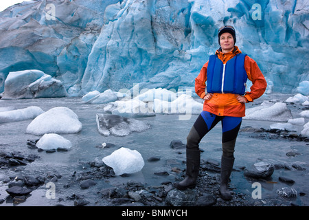 Female kayaker standing at the shoreline in front of Shoup Glacier,  Shoup Bay State Marine Park, Prince Wlliam Sound, Alaska Stock Photo