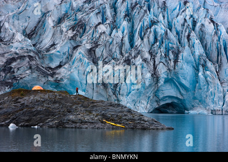 Kayaker and boat pulled up on an island in front of Shoup Glacier, Shoup Bay State Marine Park, Prince William Sound, Alaska Stock Photo