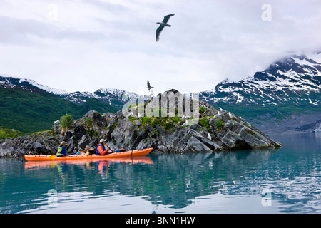 Family sea kayaking next to a small rock island, Shoup Bay, Shoup Bay State Marine Park, Prince William Sound, Alaska, USA. Stock Photo