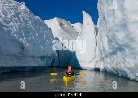 A kayaker paddles and explores the seracs of Mendenhall Glacier on a crisp Fall morning, Alaska Stock Photo