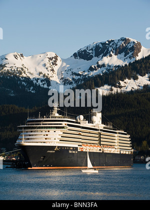 A sailboat passes in front of the docked Holland America Line cruise ship/n'Zuiderdam' in Gastineau Channel, Juneau, Alaska Stock Photo