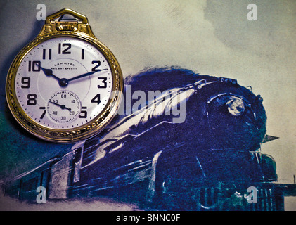 close up of antique mens railroad style pocket watch on retro image of steam locomotive train engine Stock Photo