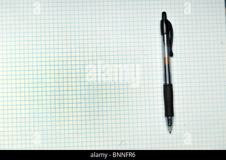 Blank grid paper with pen resting on top. Copy space on the left Stock Photo