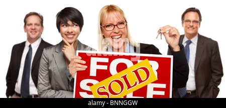 Real Estate Team Behind with Blonde Woman in Front Holding Keys and Sold For Sale Real Estate Sign Isolated on White Background Stock Photo