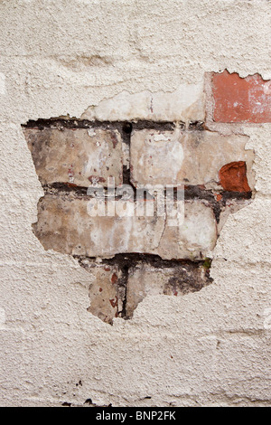 House Maintenance, paint flaking off badly maintained brickwork in need of pointing Stock Photo