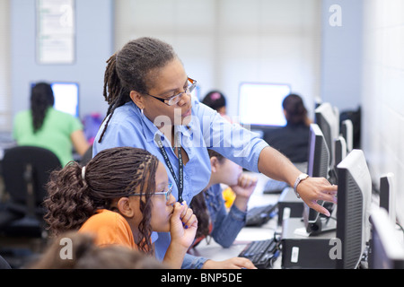 African-American female teacher instructs student using computer during video game design class at Manor New Tech High School. Stock Photo