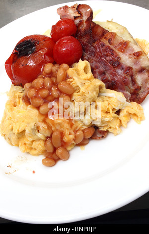 Individual portion of scrambled eggs baked beans bacon tomatoes Stock Photo