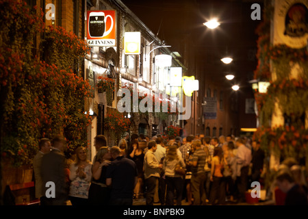 crowds of people outside the duke of york pub at night in Belfast city centre Northern Ireland UK. Stock Photo