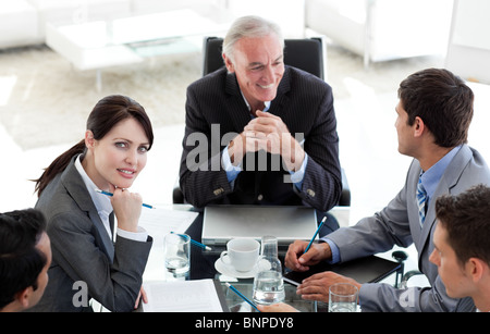 Business people sitting around a conference table Stock Photo