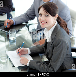 Smiling businesswoman studying a document in a meeting Stock Photo