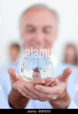 Senior businessman holding a crystal ball Stock Photo