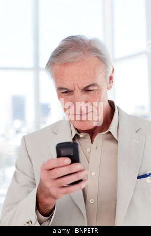 Concentrated senior businessman sending a text Stock Photo