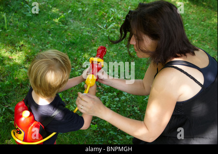 Young child boy playing fire fighter garden outside Stock Photo