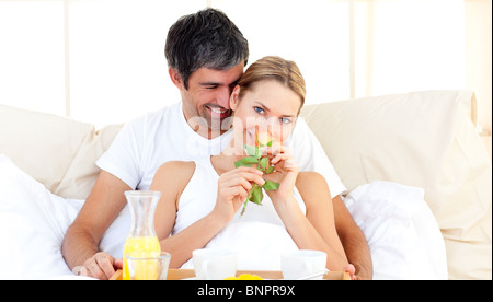 Couple having breakfast lying in the bed Stock Photo