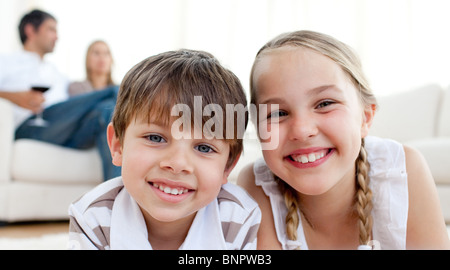 Smiling siblings lying on the floor Stock Photo
