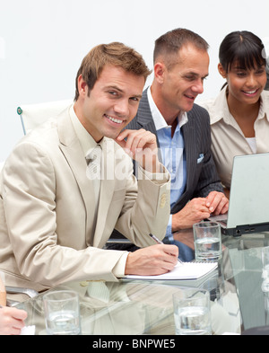 Smiling young businessman making notes Stock Photo