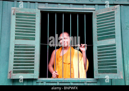 Monk looking out a window, Phnom Penh, Cambodia Stock Photo