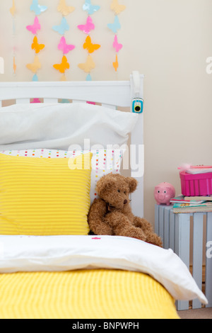 Child's bedroom with a teddy bear on the bed Stock Photo