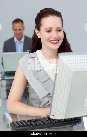 Smiling business people working at computers Stock Photo