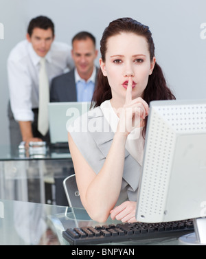 Businesswoman asking for silence in the office Stock Photo