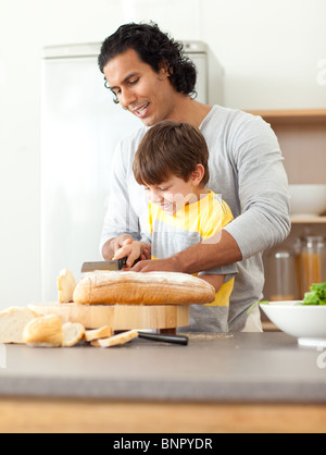 Attentive father helping his son cut some bread Stock Photo