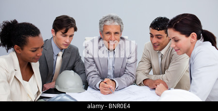 Architect manager in a meeting with his team studying plans Stock Photo