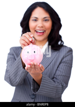 Self-assured young businesswoman saving money in a piggybank Stock Photo