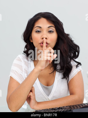 Businesswoman asking for silence in the office Stock Photo