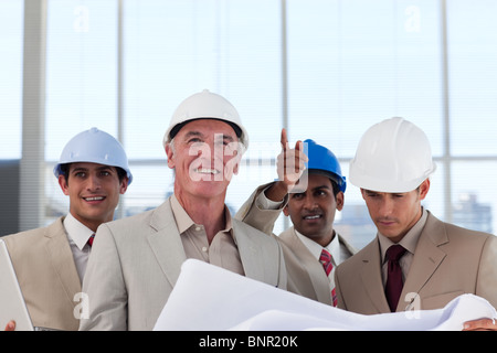 A group of architects discussing a construction plan Stock Photo