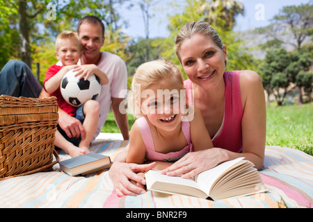 Mother and her daughter reading lying on a picnic tablecloth Stock Photo