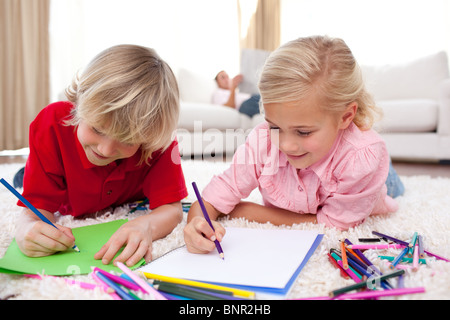 Concentrated children drawing lying on the floor Stock Photo