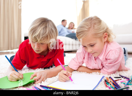 Cute siblings drawing lying on the floor Stock Photo