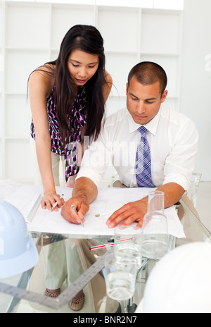 Two architects discussing a construction plan in the office Stock Photo