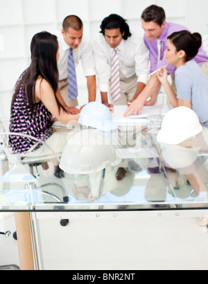 A group of architects studying plans in a meeting Stock Photo